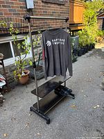 Assembled rack with hanging bar, two shelves, casters, displaying scale