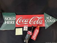 Front view of sign with two bottles and pin set