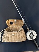 Rod and reel resting on open wicker creel showing overall items