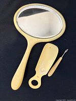 Front view of hand mirror, shoe horn and cuticle tool