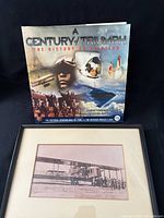 Front view of book with dust jacket alongside framed print