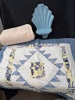 Shower curtain, ceramic wall sconce, quilt laid out