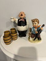 Front view of decanter, four shot glasses, boy figurine