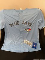 Front of light blue Blue Jays jersey with logo and glasses bag