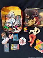 Overview of tin with pins, chalkware figures and lid