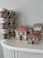 Set assembled showing mugs stacked and teapot, sugar bowl, shakers