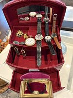 Overall view of jewellery case open with watches and jewellery displayed