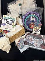 Overall view showing knitting looms, floss pack, book, lace collars and basket
