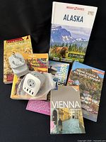 Group shot of all travel guidebooks and both outlet adaptors