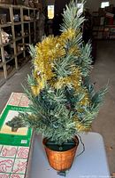 Full view of 3-ft artificial pine tree with basket base, lights cord visible
