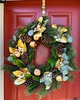 Full view of wreath hanging on red door, shows overall design and size