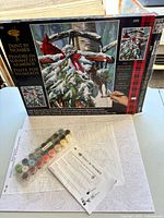 Front of open box, art board, paint pots and instructions visible