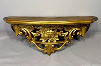 Front view of gold Syroco wall shelf