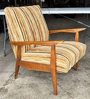 Front angled view of chair showing wood frame, striped upholstery, tapered legs
