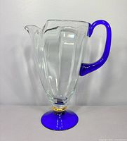 Full view of clear crystal pitcher showing cobalt handle and foot