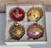 Open box showing top view of four ornaments