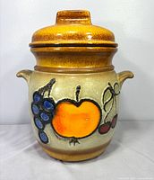 Front view showing complete jar with lid and fruit motif
