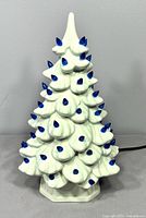 Front view of white ceramic Christmas tree with blue pegs