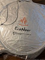 EcoNour sunshade showing silver material, logo, and elastic closure