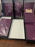Five boxed purple wallets showing exterior and interior layout