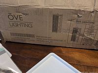 Boxed OVE Lighting Ashcombe III vanity fixture with model and LED inclusion printed on carton