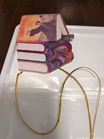close view of one Harry Potter book stack ornament showing cover art and gold cord
