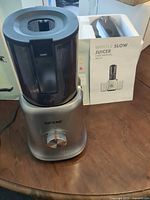 Juicer motor base with hopper, manual, and box on table