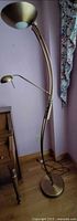 Full view of brass torchiere floor lamp with reading arm