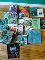 Wide view of entire assortment of gardening and nature books laid out on floor