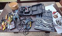 Overview of assorted power tools, socket set, hand tools and clamps on table