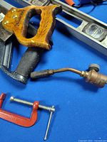 Wood-handled saw, spirit level, C-clamp, torch head