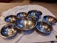All seven stainless steel nesting bowls displayed with water bottle for scale