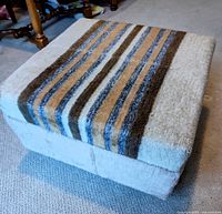 Full view of ottoman showing striped top and beige sides