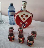 Full set on table: leather-covered flask and six shot glasses