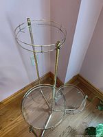 Full view of three-tier plant stand showing metal frame and glass shelves