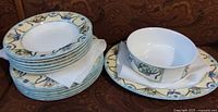 Stacked dinner plates and serving bowl displaying floral ribbon pattern