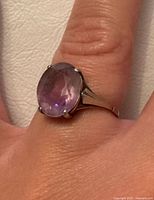 Ring worn on finger showing amethyst and setting