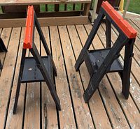 Two folding sawhorses standing on deck, showing overall form and folding legs
