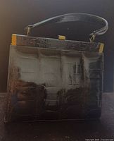 Front view of dark brown alligator leather handbag showing scale pattern and handle