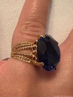 Side view of ring on finger showing split rope band and sapphire setting