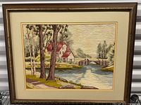 Full view of framed crewel embroidery landscape