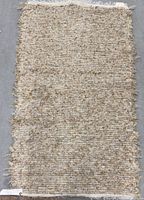 Full view of rectangular wool rug showing overall texture and fringed end
