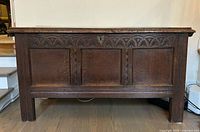 Front view showing carved panels, lock, overall form