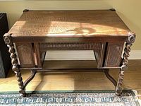 Full view of oak desk front, showing barley twist legs, cane panels, stretcher