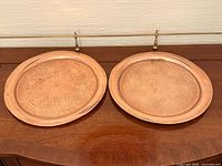 Full view of both engraved copper trays on table