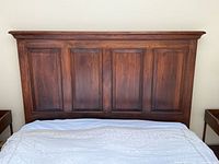 Front view of solid wood paneled headboard against wall