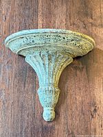 Front view of wooden wall sconce shelf mounted on wood backdrop