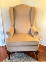 Front view of upholstered wingback armchair