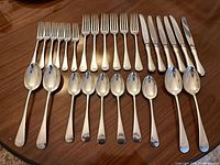 Flatware set laid out showing forks, knives, spoons