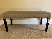 Front view of grey upholstered bench